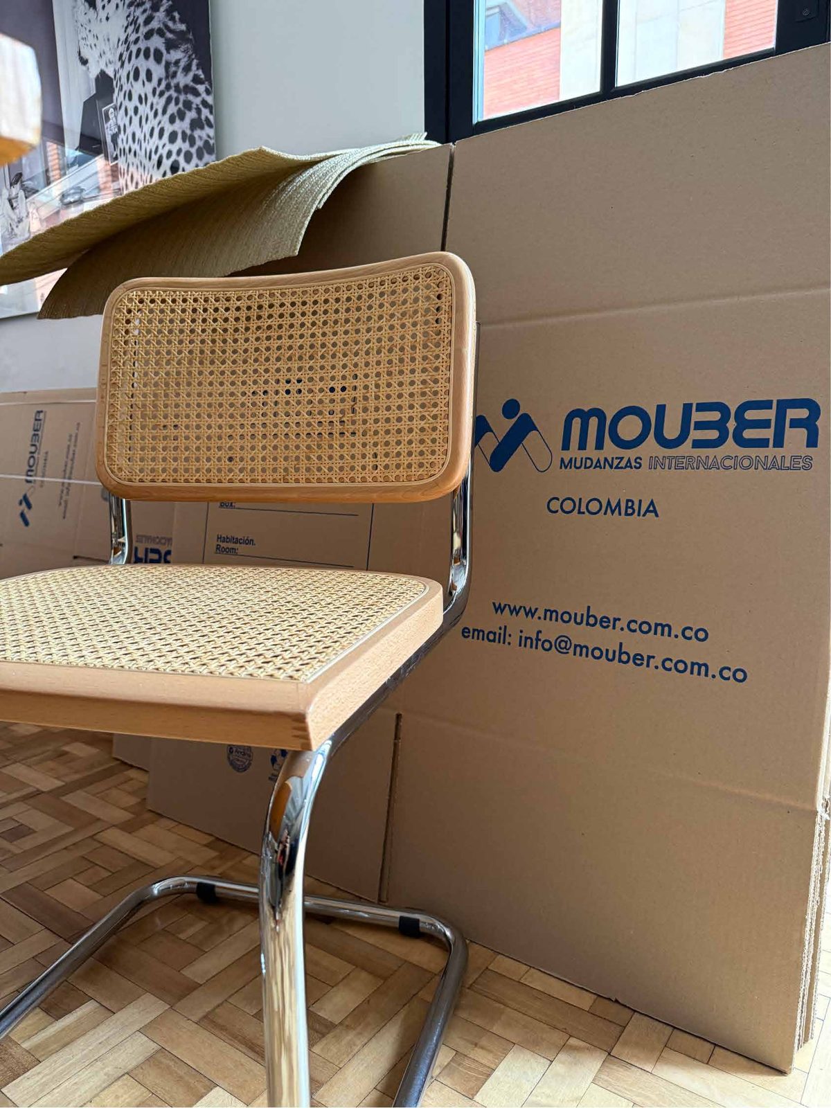 Silla y cajas de cartón Mouber preparadas para el traslado de una oficina